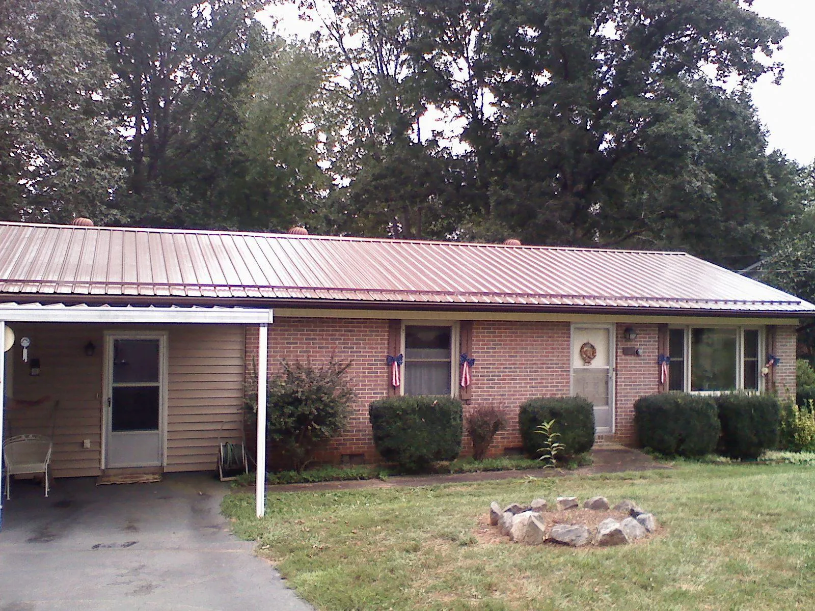 Bronze metal roof and carport on a brick ranch home — Roof Repair work by our crew in Hardyville